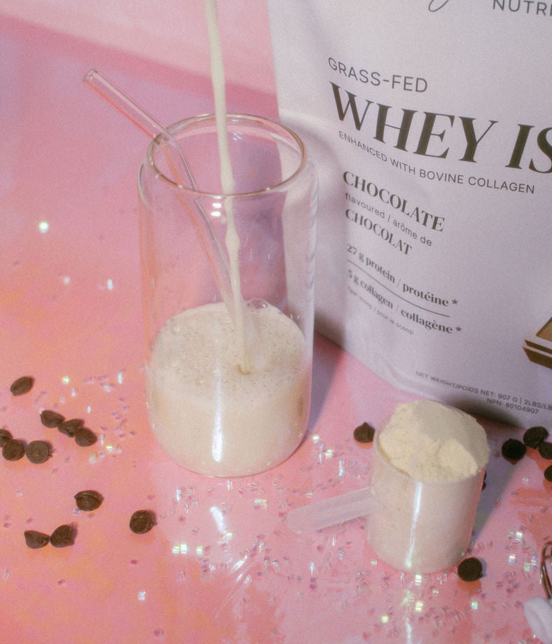 Whey protein isolate powder being poured into a glass with a pink gradient background